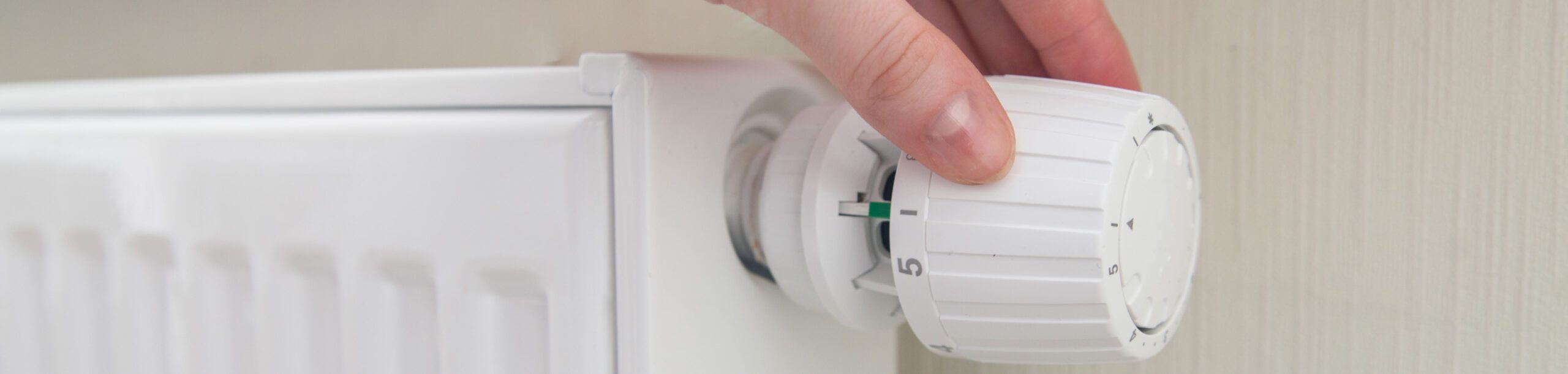 Mano ajustando un termostato de radiador